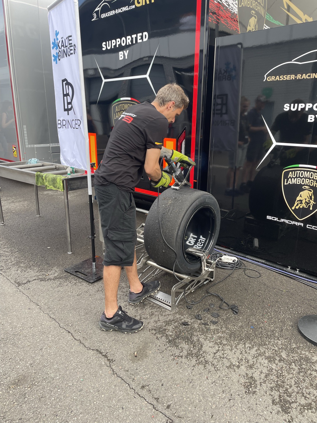 Mecânico da GRT com um pneu traseiro de Lamborghini